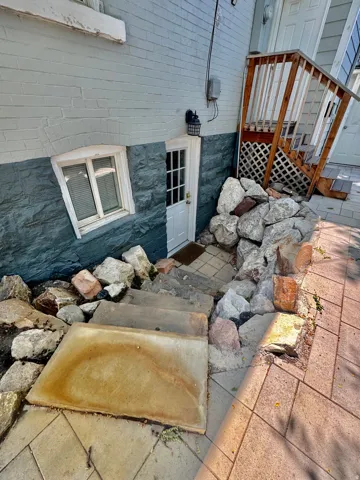 Lower-level entry with a light blue painted brick exterior and dark blue stone veneer