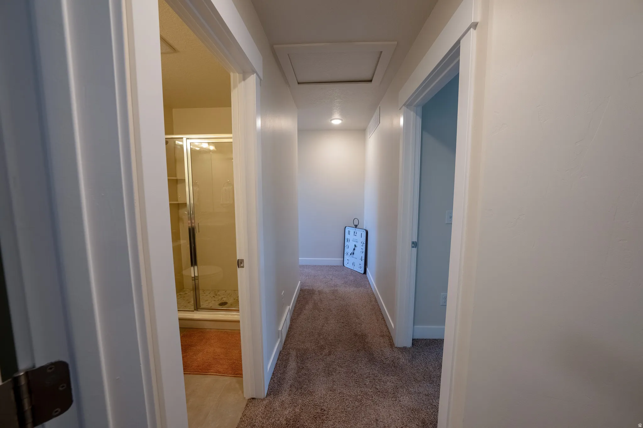Carpeted hallway with white trim, recessed lighting, and access panel