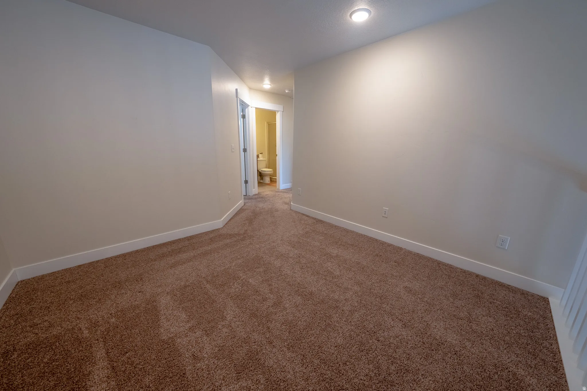 Carpeted flooring, recessed lighting, and crisp white trim