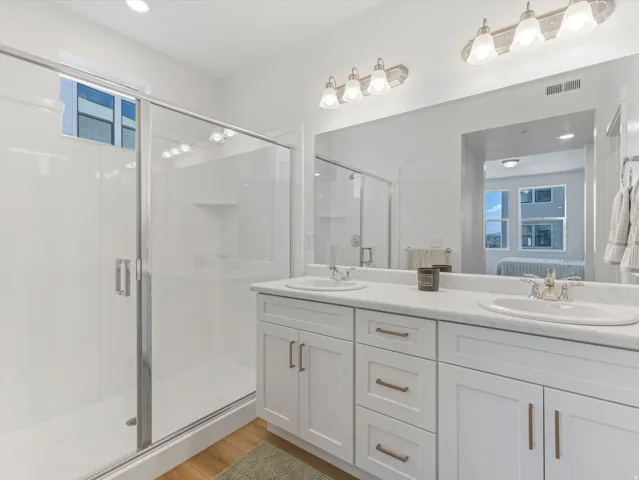 Dual vanity with undermount sinks, white cabinetry, and brushed nickel hardware