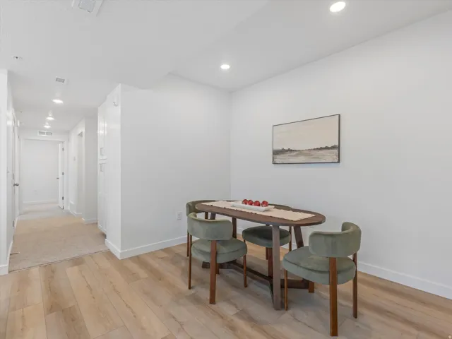 Recessed ceiling lighting, durable wood-finish flooring, and white painted walls