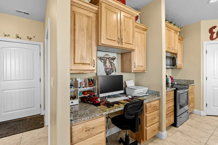 Built-in desk with granite countertop and wood-finish cabinetry