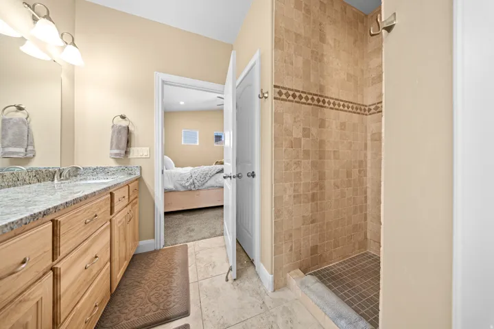 Dual vanity with integrated sinks, light-toned wood cabinetry, and a speckled countertop