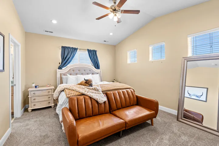 Vaulted ceiling with a ceiling fan, recessed lighting, carpet flooring, and multiple windows with blinds