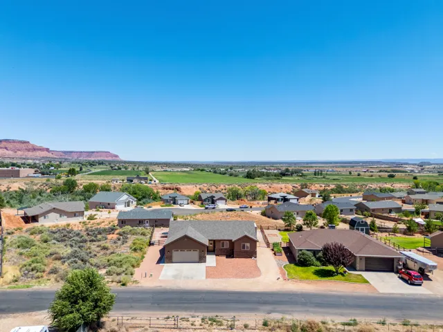 Single-story home with an attached garage, featuring a gravel driveway and a landscaped front yard
