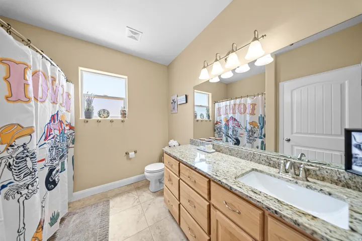 Extended vanity with an integrated sink, granite countertop, and wood-finish cabinetry