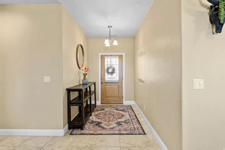 Tile flooring entrance with a wood-finish door and transom window