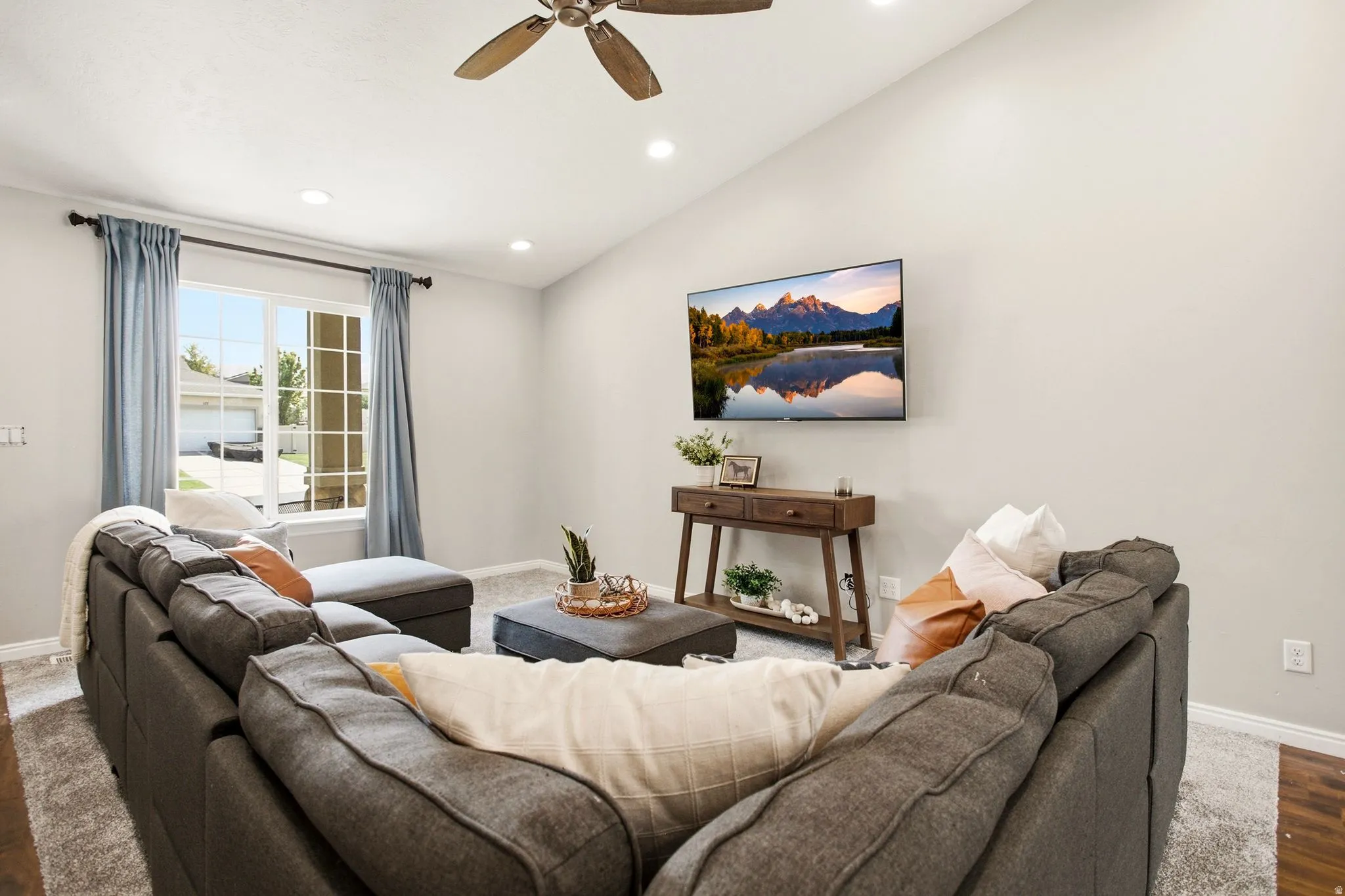 Vaulted ceiling with recessed lighting and a ceiling fan
