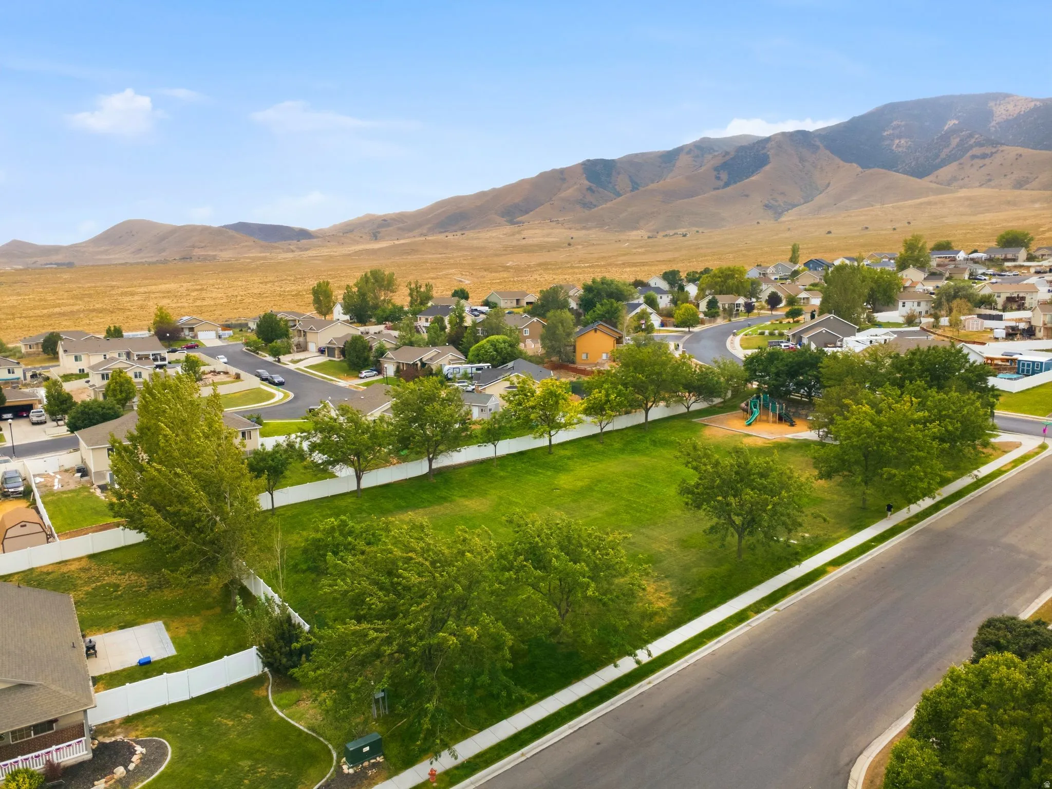 Neighborhood green space featuring mature trees and playground equipment