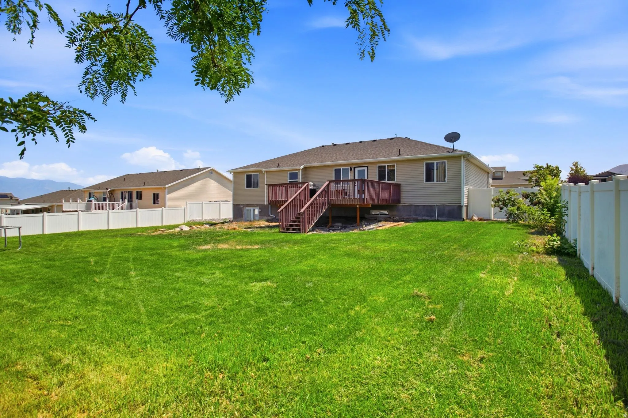 Expansive rear lawn with a full vinyl fence