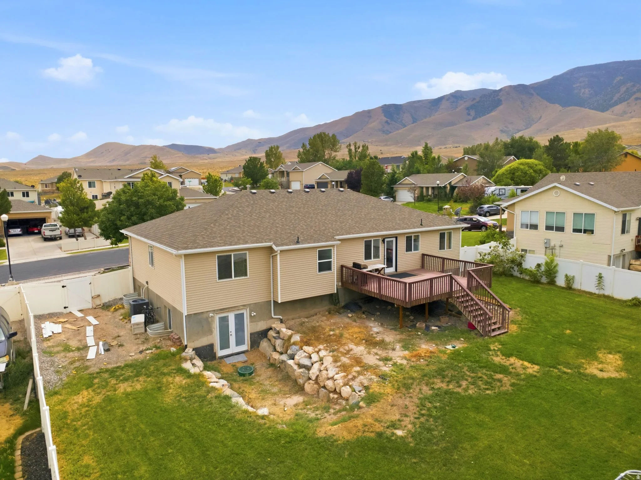 Expansive backyard featuring a multi-level wooden deck, dual-pane windows, and a lower-level double door entry