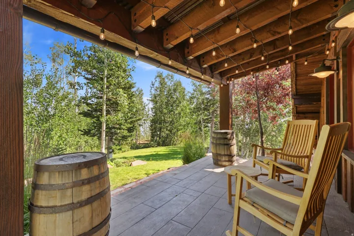 Covered patio with a wood ceiling, strung decorative lighting, and a textured concrete surface