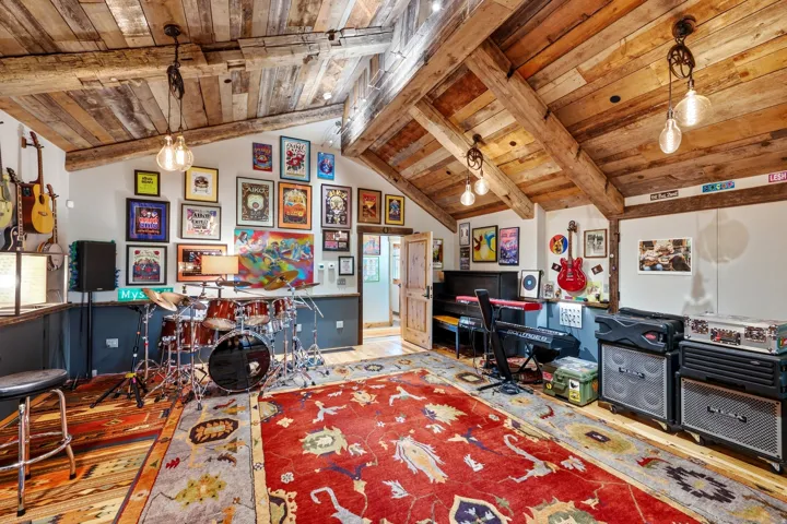 Vaulted wood-paneled ceilings with exposed wood beams, wall sconces, and recessed lighting