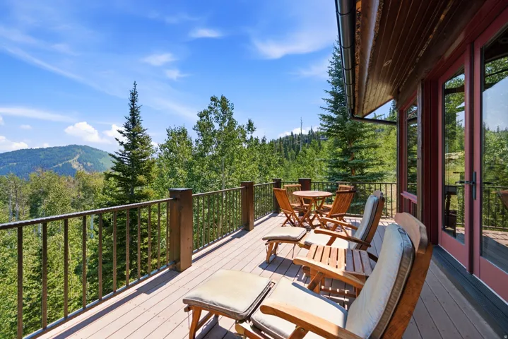 Expansive outdoor deck with a durable composite surface, robust wood railings, and a rich wood-paneled exterior facade