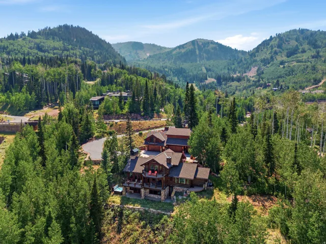 Log cabin-style exterior with stone accents, multiple balconies, and a multi-level structure