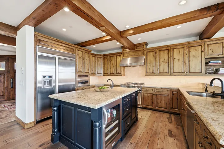 Exposed wood beams and wood-finish flooring complement the natural wood cabinetry