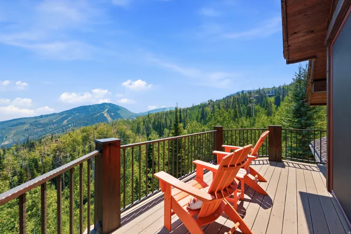 Expansive outdoor deck featuring wood-finish flooring and a metal railing