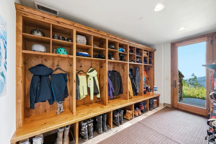 Built-in wood storage system with individual cubbies, hooks, and bench seating