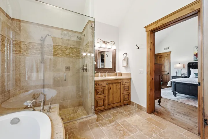 Glass-enclosed shower with tile surround and mosaic accent