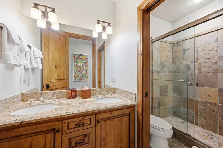Double vanity with light-toned granite countertop and integrated sinks