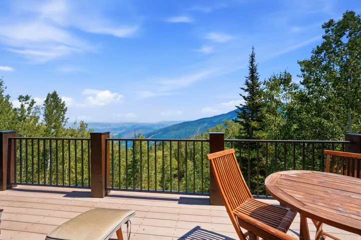 Expansive outdoor deck featuring wood-finish flooring and a metal railing