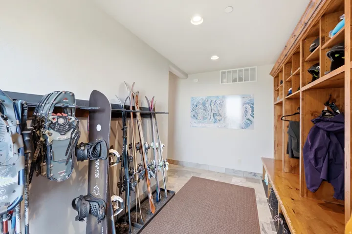 Built-in wooden shelving with individual compartments, recessed lighting, and tile flooring