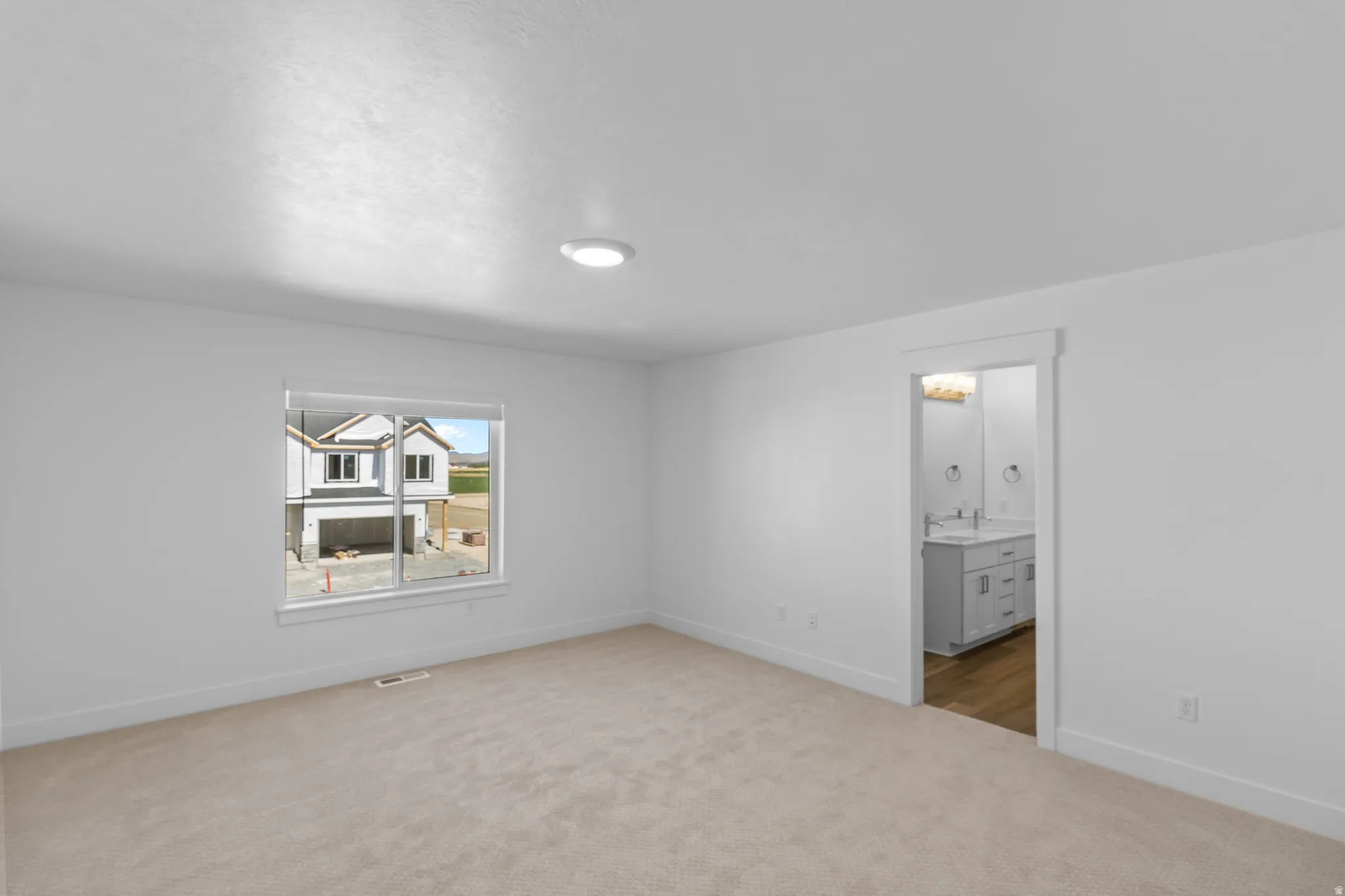 Plush carpet flooring, recessed ceiling lighting, and a framed doorway