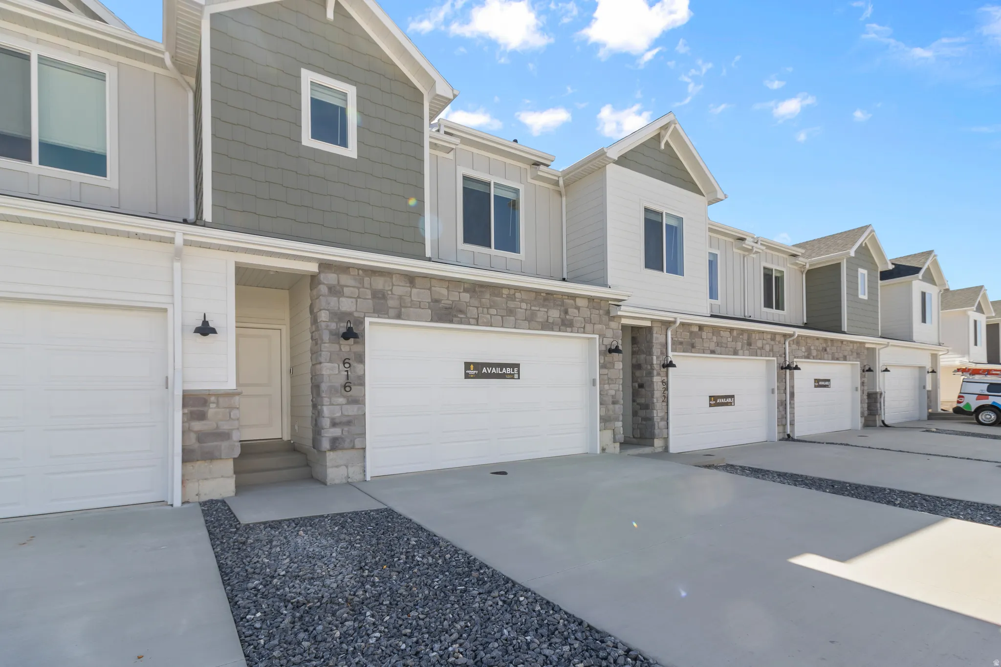 Contemporary townhome exterior featuring stone accents, vertical siding, and shake siding
