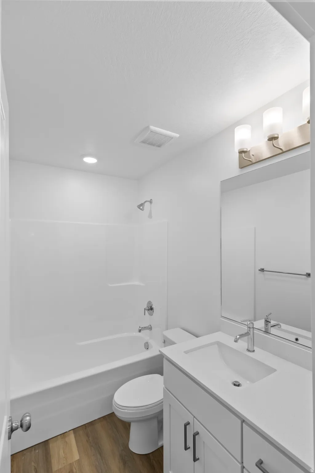 White vanity with an integrated rectangular sink, chrome faucet, and matte black hardware