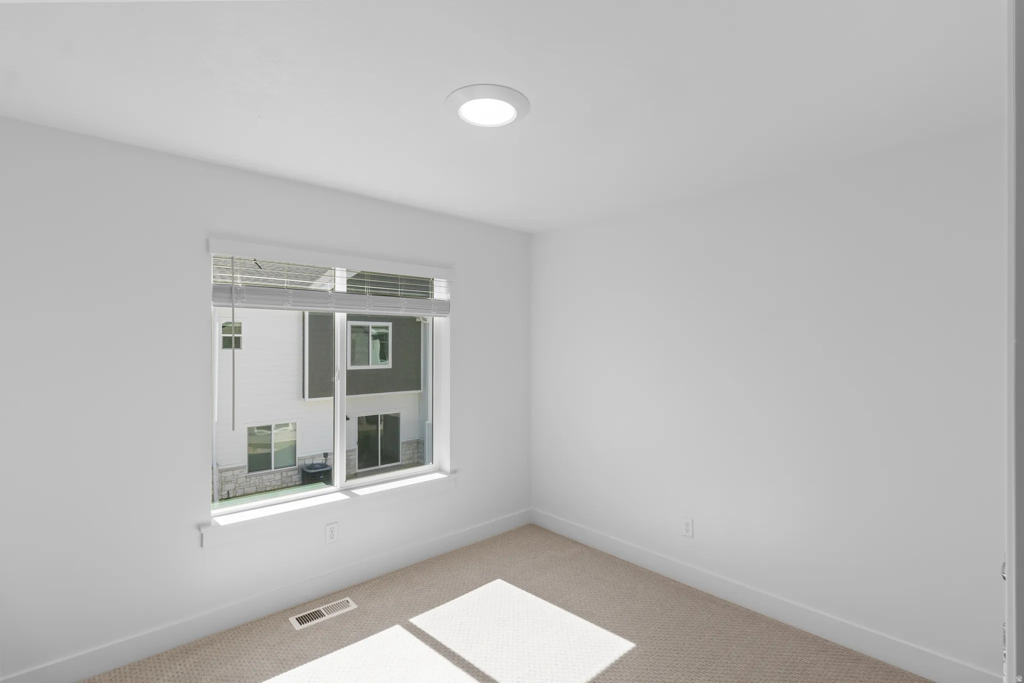 Neutral wall finishes, recessed lighting, and carpeted flooring