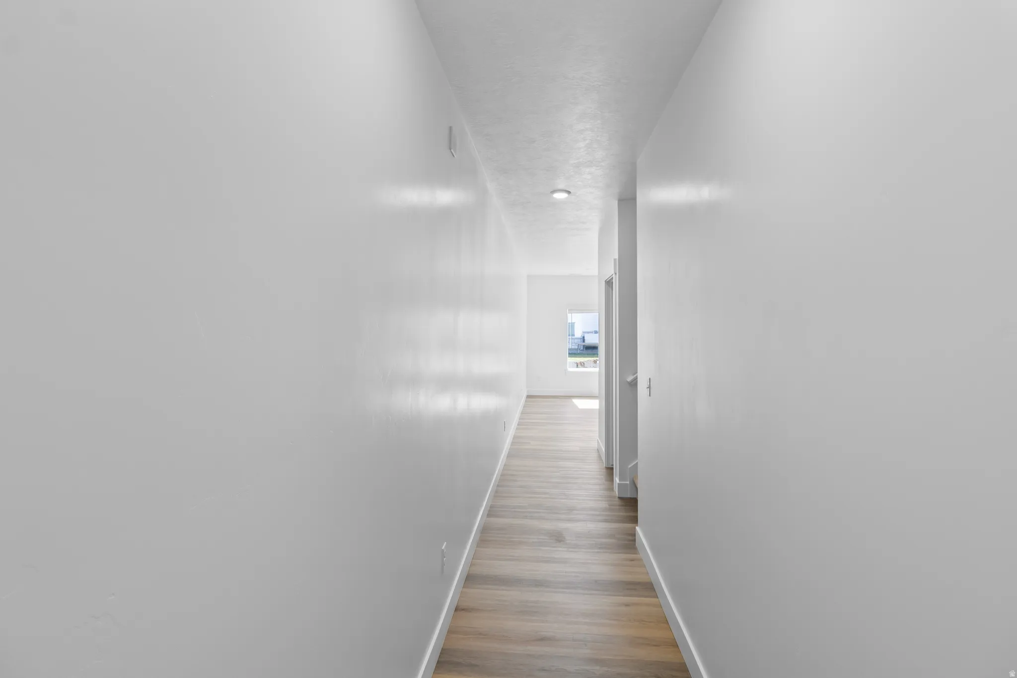 Recessed ceiling lighting, light wood-finish flooring, and crisp white walls