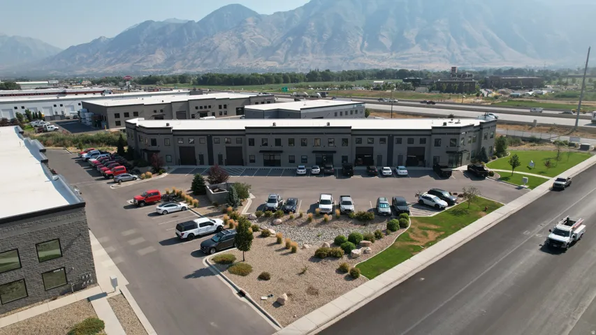 Commercial building with a dark gray exterior, multiple ground-level bay doors, and a paved parking lot
