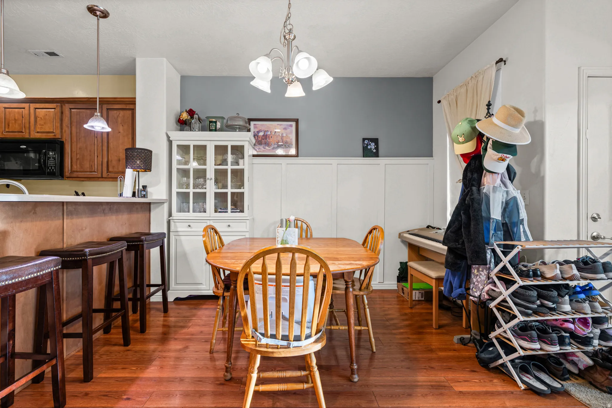 Open-concept living space featuring wood-finish flooring, a kitchen with a breakfast bar, and a dedicated dining area