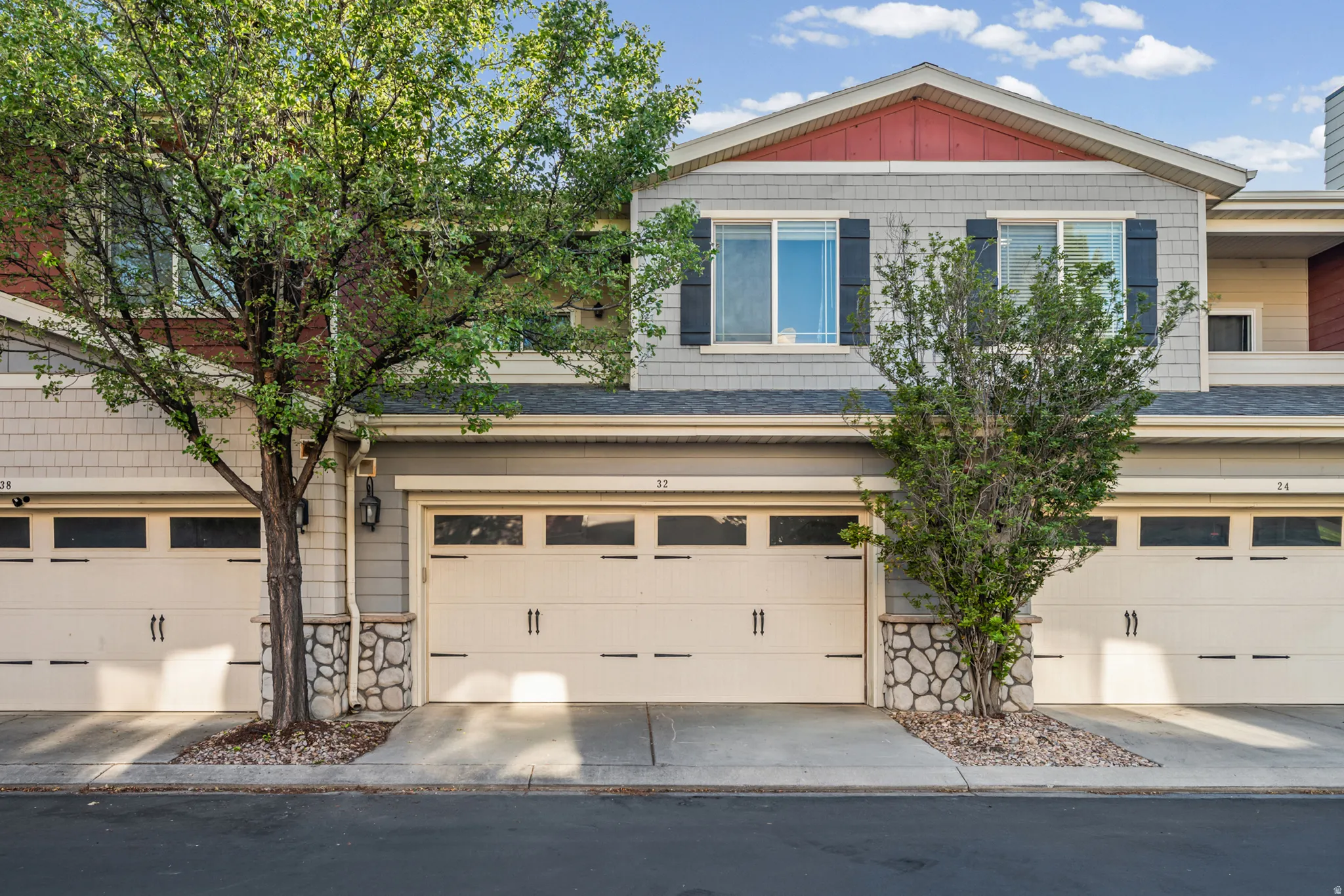 Multi-level townhome exterior featuring an attached two-car garage with transom windows