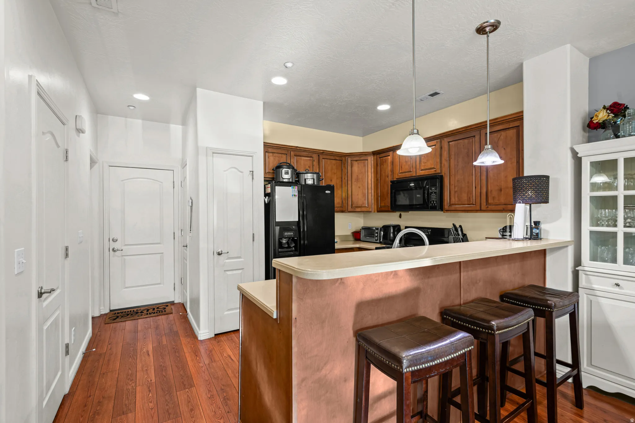 Kitchen featuring wood-finish flooring, recessed lighting, and a breakfast bar with pendant lighting
