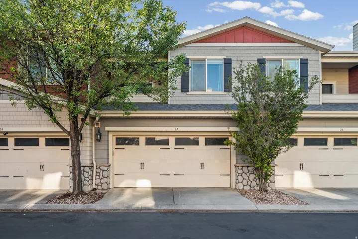 Multi-level townhome exterior featuring an attached two-car garage with transom windows