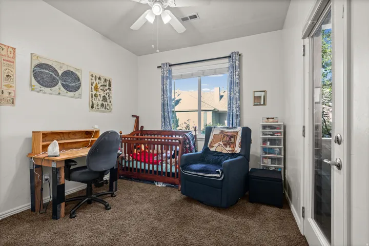 Bright room with a ceiling fan, large window, and glass-paneled door