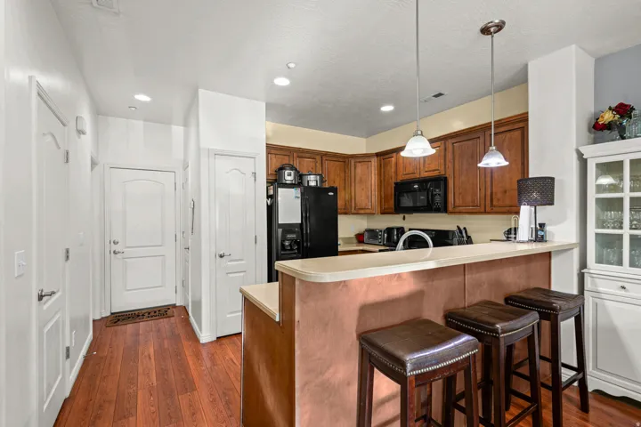 Kitchen featuring wood-finish flooring, recessed lighting, and a breakfast bar with pendant lighting