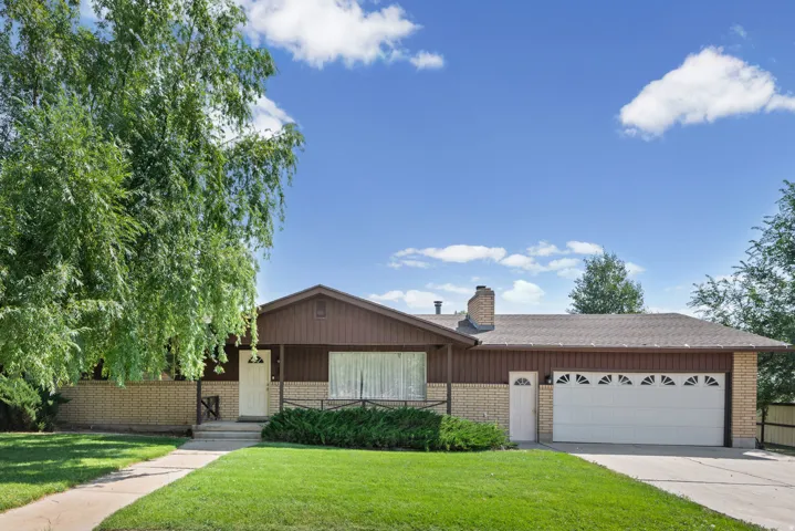 Ranch-style exterior with a brown wood-paneled facade, light brick accents, and a front porch