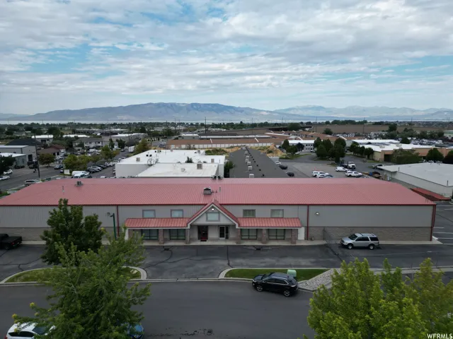 Expansive commercial building featuring a red metal roof and neutral-toned exterior siding