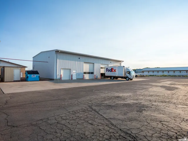 Industrial building with multiple bay doors and a large paved lot