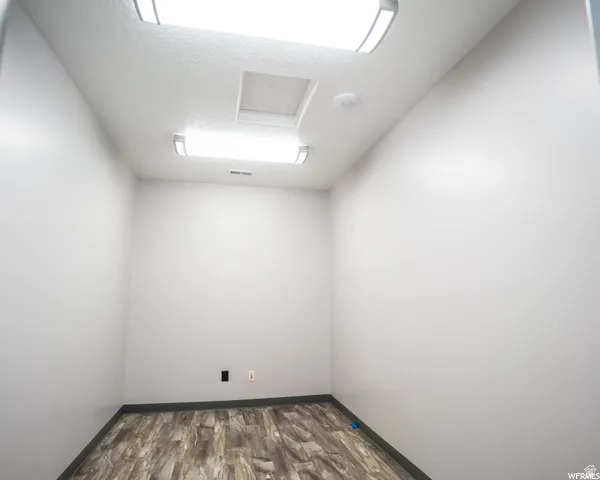Recessed ceiling lighting, wood-finish flooring, and light-toned walls