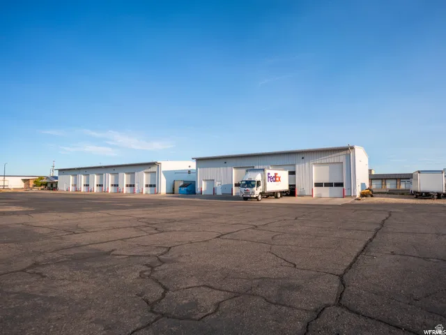 Expansive paved lot with multiple industrial buildings featuring numerous roll-up doors