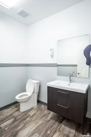 Floating vanity with integrated sink, chrome faucet, and dark wood-finish cabinetry
