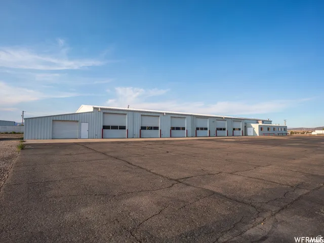 Metal-clad building with multiple overhead doors and an expansive paved lot