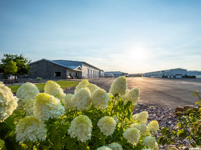 Expansive paved lot with multiple industrial-style buildings featuring metal roofs and stone accents