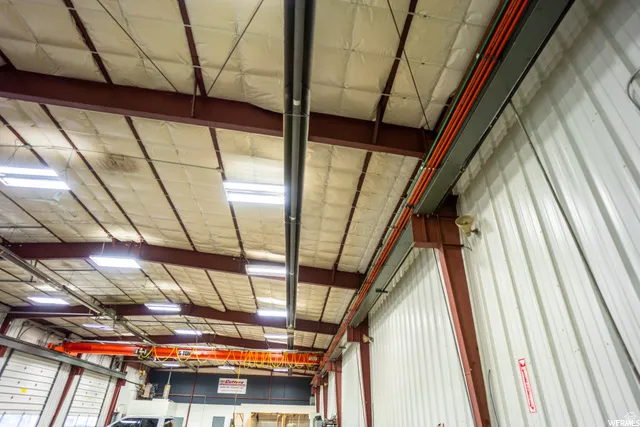 Industrial interior with exposed structural beams, corrugated metal wall panels, and overhead lighting