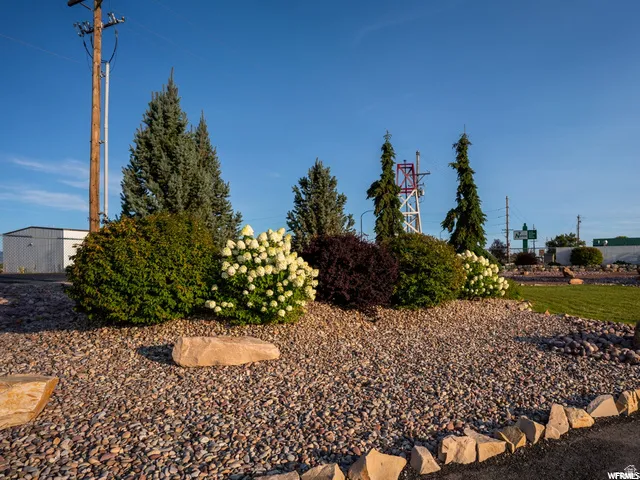 Landscaped area featuring varied shrubs, decorative rocks, and a gravel ground cover