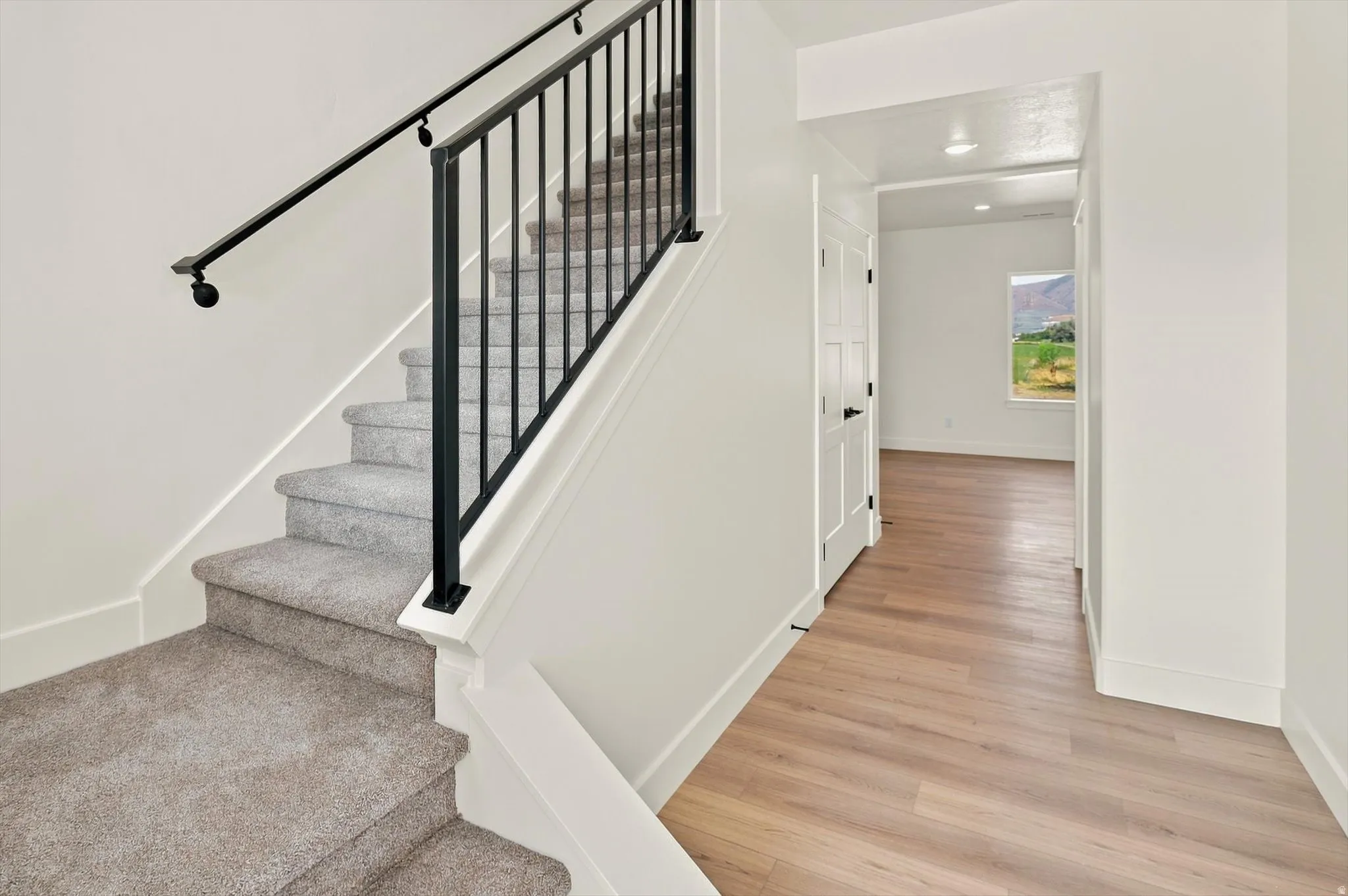 Carpeted staircase with dark metal balusters and handrail