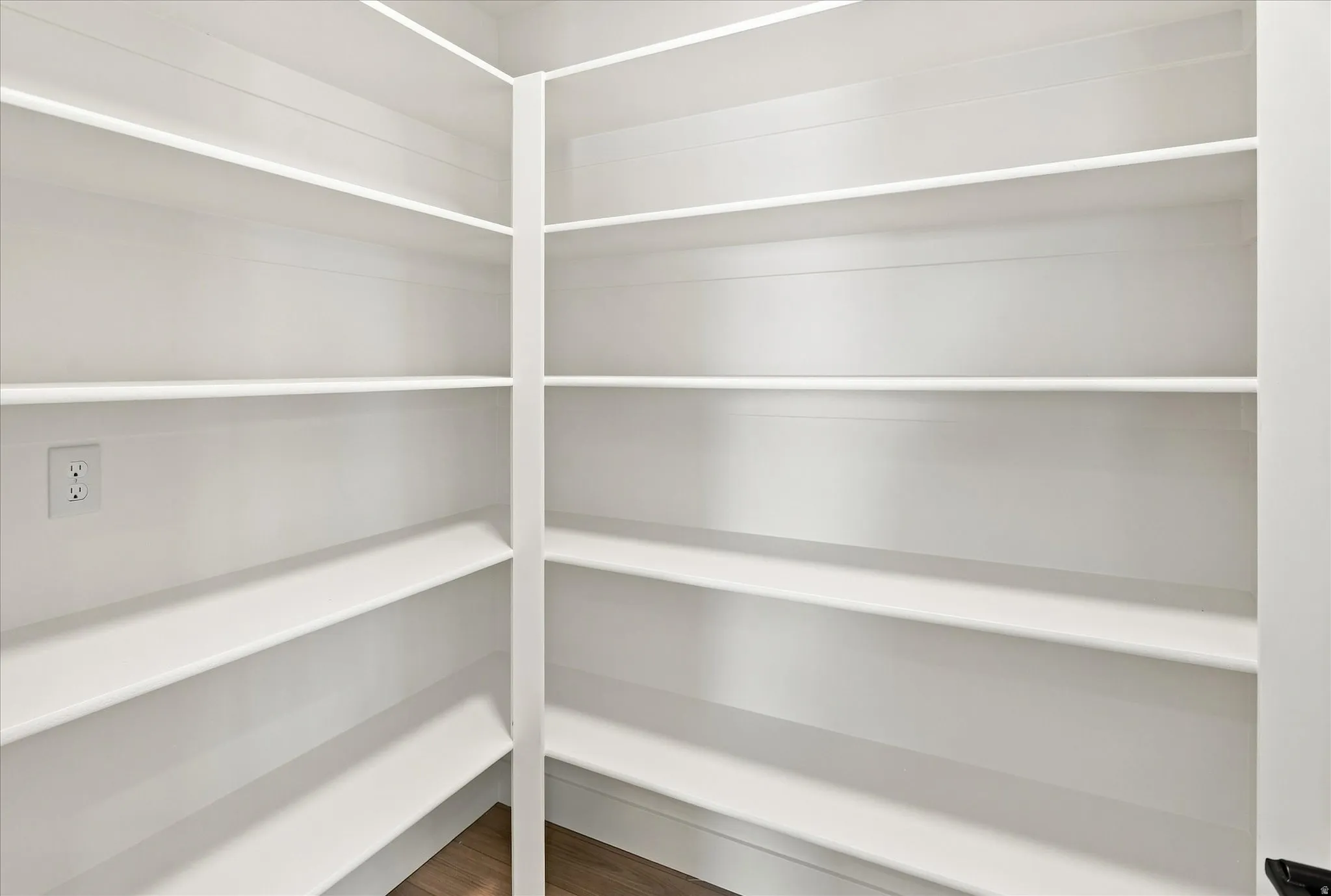 Built-in shelving, white finish, wood-finish flooring, electrical outlet